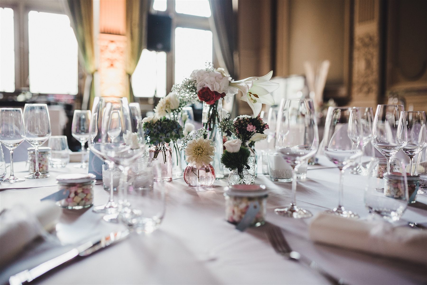 Florale Tischdekoration mit zarten Blüten und Gläsern bei einer Hochzeit im Ordenssaal Bonn