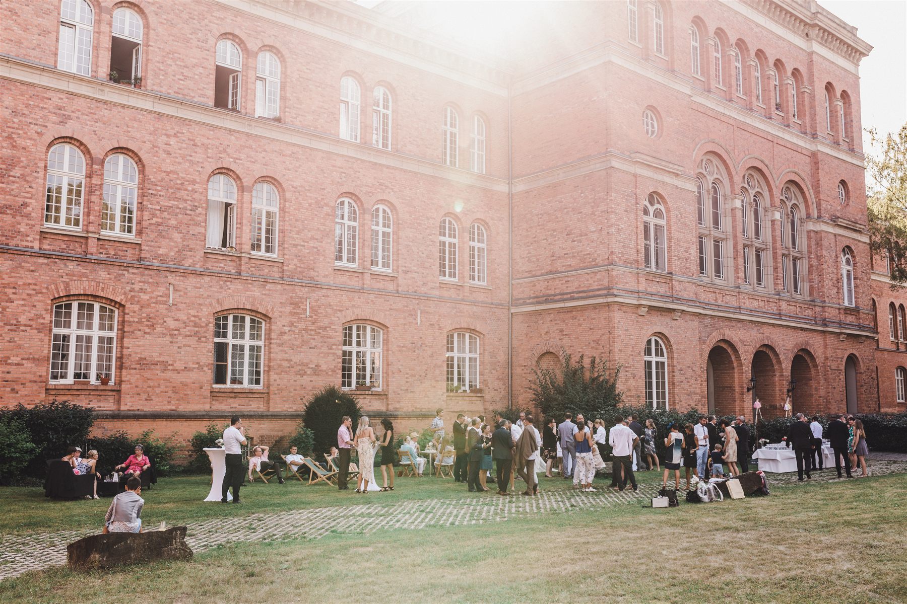 Historisches Backsteingebäude des Ordenssaals Bonn mit Gartenempfang einer Hochzeit in der Abendsonne