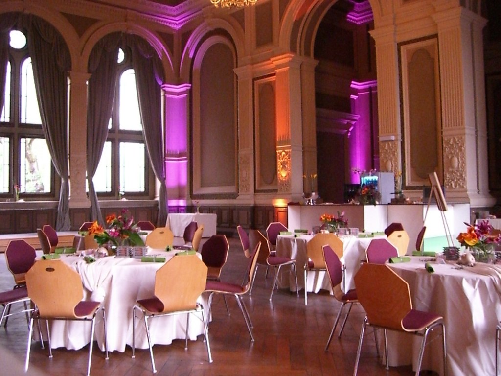 Der Ordenssaal Bonn in warmes und violettes Ambientelicht getaucht, festlich eingedeckt